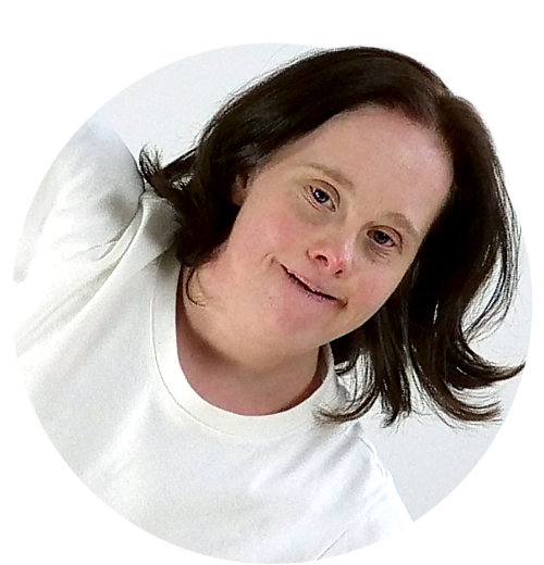 Porträtt av en person i vit t-shirt. Hon lutar sig åt sidan.