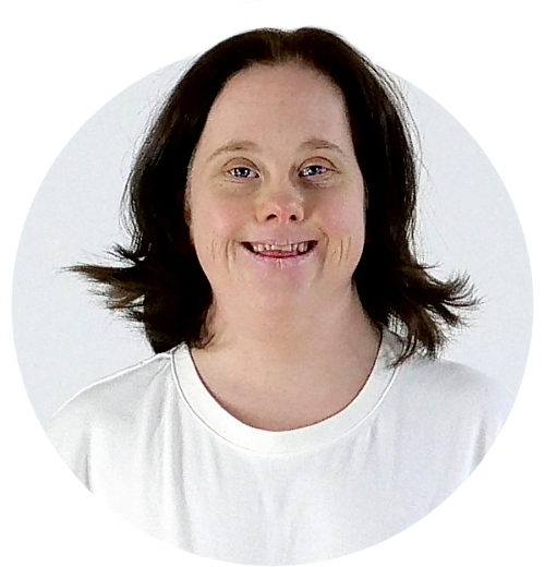 Porträtt av en person i vit t-shirt. Hon ler.