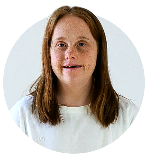 Porträtt av en person i vit t-shirt. Hon ler.